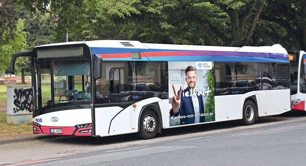 Linienbus mit großflächiger Karrierewerbung des Kreises Viersen fährt durch den Stadtverkehr und wirbt für Jobs.