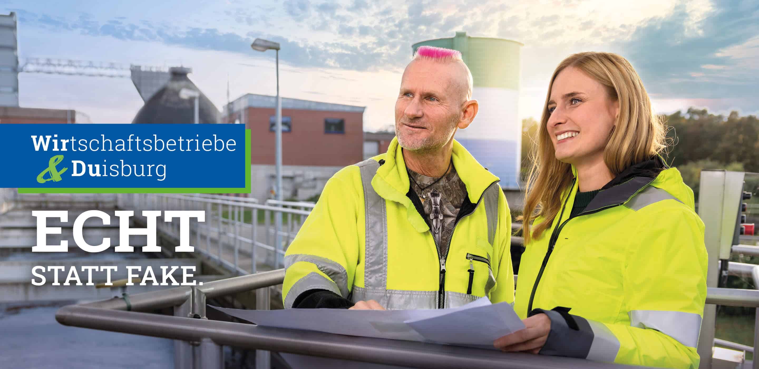 Zwei Mitarbeitende der Wirtschaftsbetriebe Duisburg besprechen Unterlagen auf einer Anlage unter dem Motto „Echt statt Fake“.